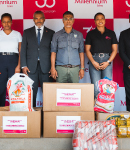 Grupo de pessoas com caixas de cartão e sacos com bens essenciais