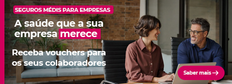 Mulher e homen sentados à secretária com um computador portátil aberto e a sorrirem